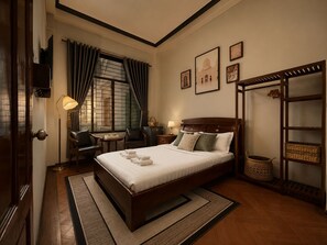 A hotel room with a large bed, a desk, a chair, a wardrobe, and a window with curtains. - Bê Tông Residences Homestay (Can Tho)