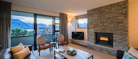 TV connectée, cheminée, livres, chaîne hi-fi