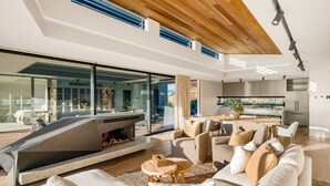 Una sala de estar moderna con chimenea, un comedor y una cocina.