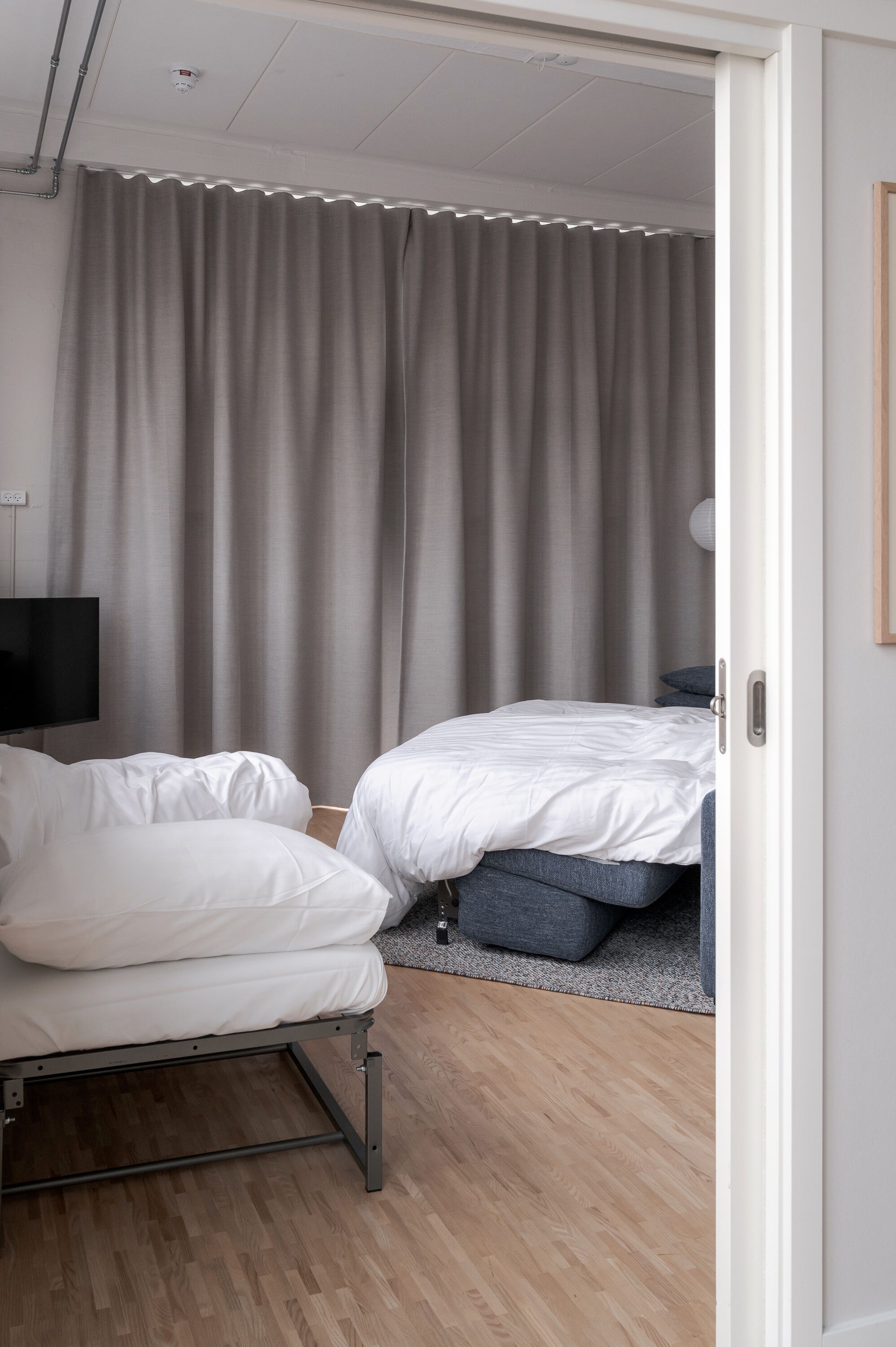 Habitació d'hotel moderna amb un llit, un sofà i una televisió.