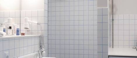 Une salle de bain équipée d’un lavabo, d’un miroir et d’un lave-linge.