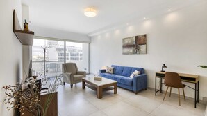 A modern living room with a sofa, coffee table, and a desk with a chair. - Gzira Penthouse (Gzira)