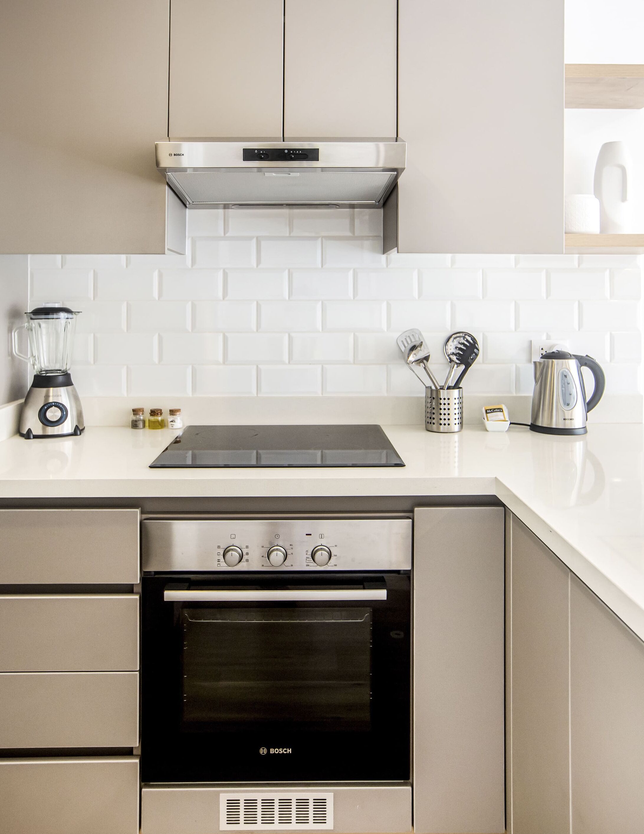 A modern kitchen with a Bosch oven, a built-in stovetop, and a range hood.