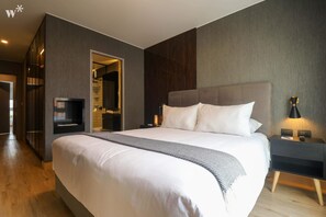 A modern hotel room with a large bed, a TV, a bedside table with a lamp, and a wardrobe. - Wynwood Pedro Bustamante in Barranco (Lima)