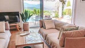 Un salon moderne avec un canapé, une table basse et un téléviseur.