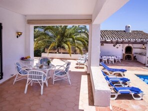 A covered outdoor area with a pool, lounge chairs, and a dining setup. - Casa Moser by Interhome (Jávea)