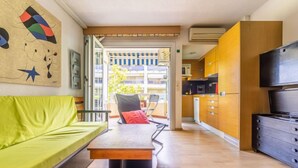 Una sala de estar moderna con un sofá verde, una mesa de centro de madera y un televisor sobre un mueble de madera.