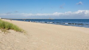 A beach with a pier extending into the sea, featuring a small structure at the end. - App.11 Zinnowitzer Hof by Interhome (Zinnowitz)