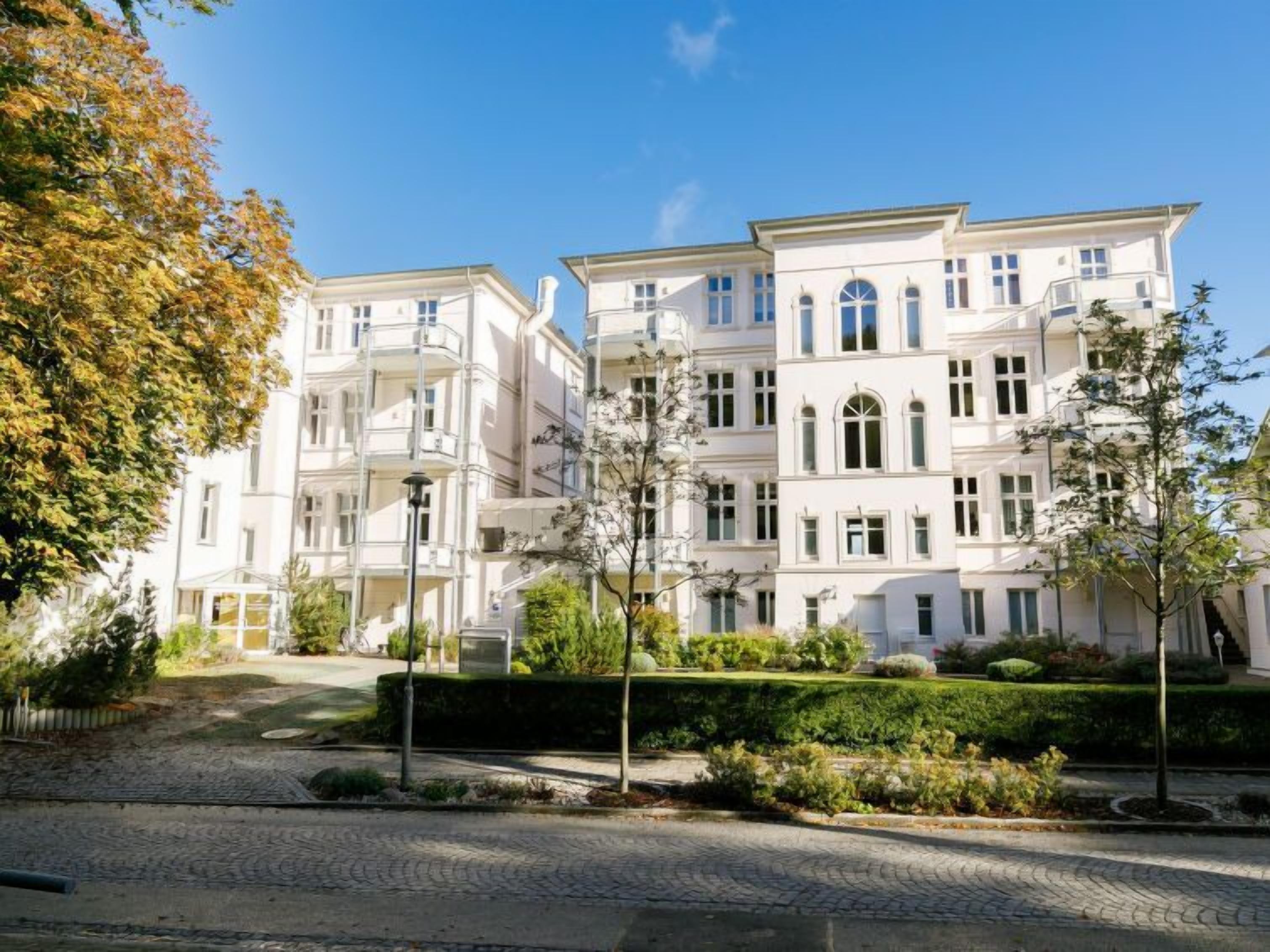A multi-story building with a symmetrical facade, large windows, and a central entrance.