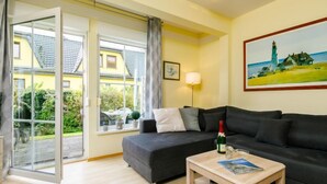 Een moderne woonkamer met een bank, een bijzettafeltje en een schilderij aan de muur.