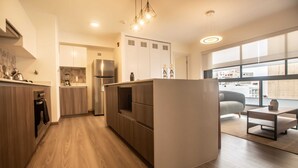 Una cocina moderna con armarios de madera, una isla integrada y un ventanal con vistas a la ciudad.