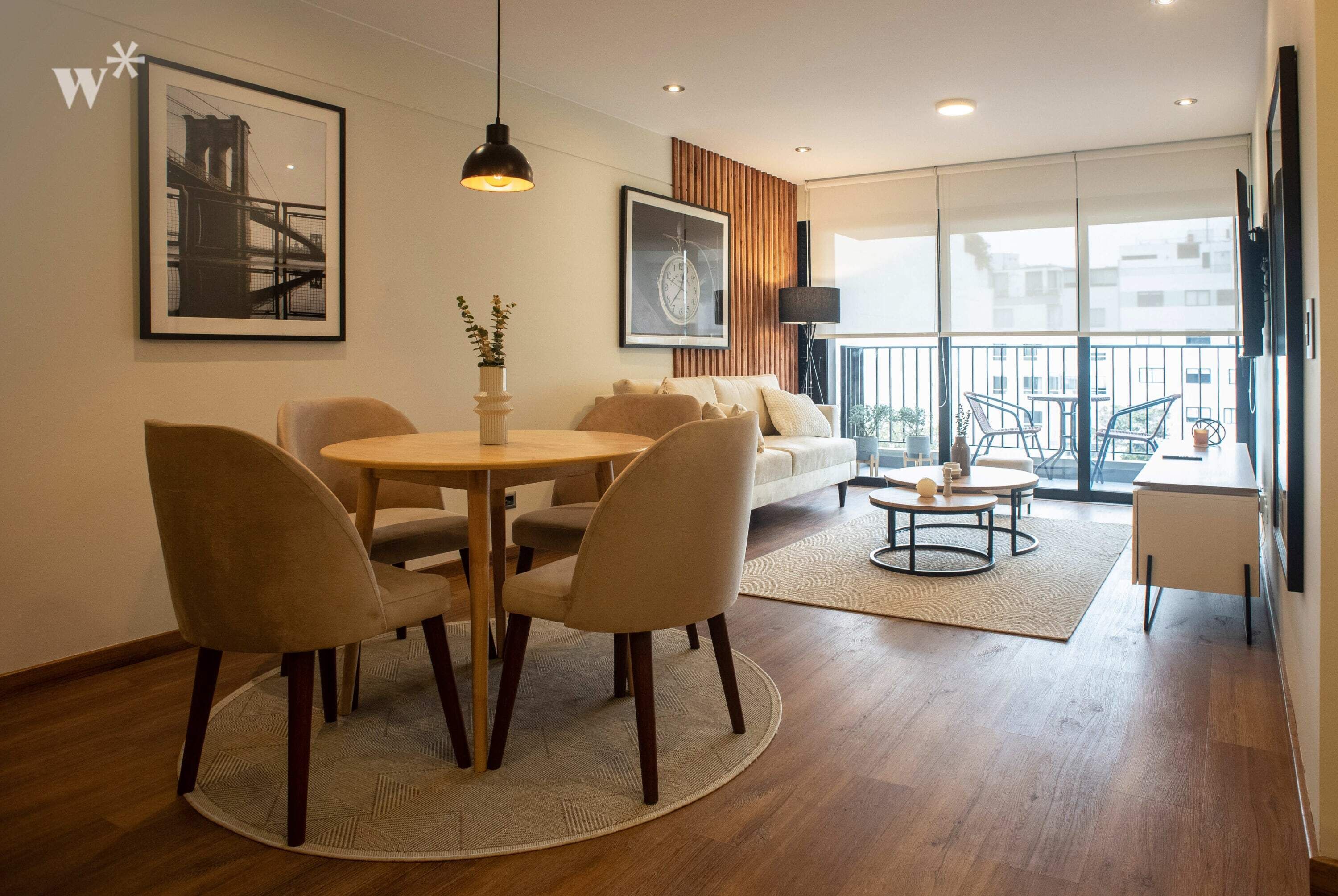 A modern living room with a dining area, a sofa set, a coffee table, and a balcony with outdoor seating.