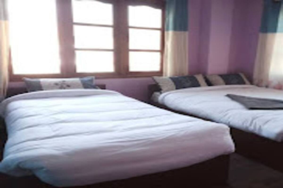 Ein Schlafzimmer mit zwei Betten, einem Fenster und Vorhängen.