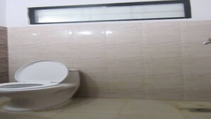 A bathroom with a toilet, a sink, and a mirror on the wall. - MeroStay 219 Yam Homestay (Kathmandu)
