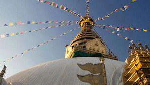 A large white stupa with a golden spire, surrounded by colorful prayer flags. - MeroStay 219 Yam Homestay (Kathmandu)