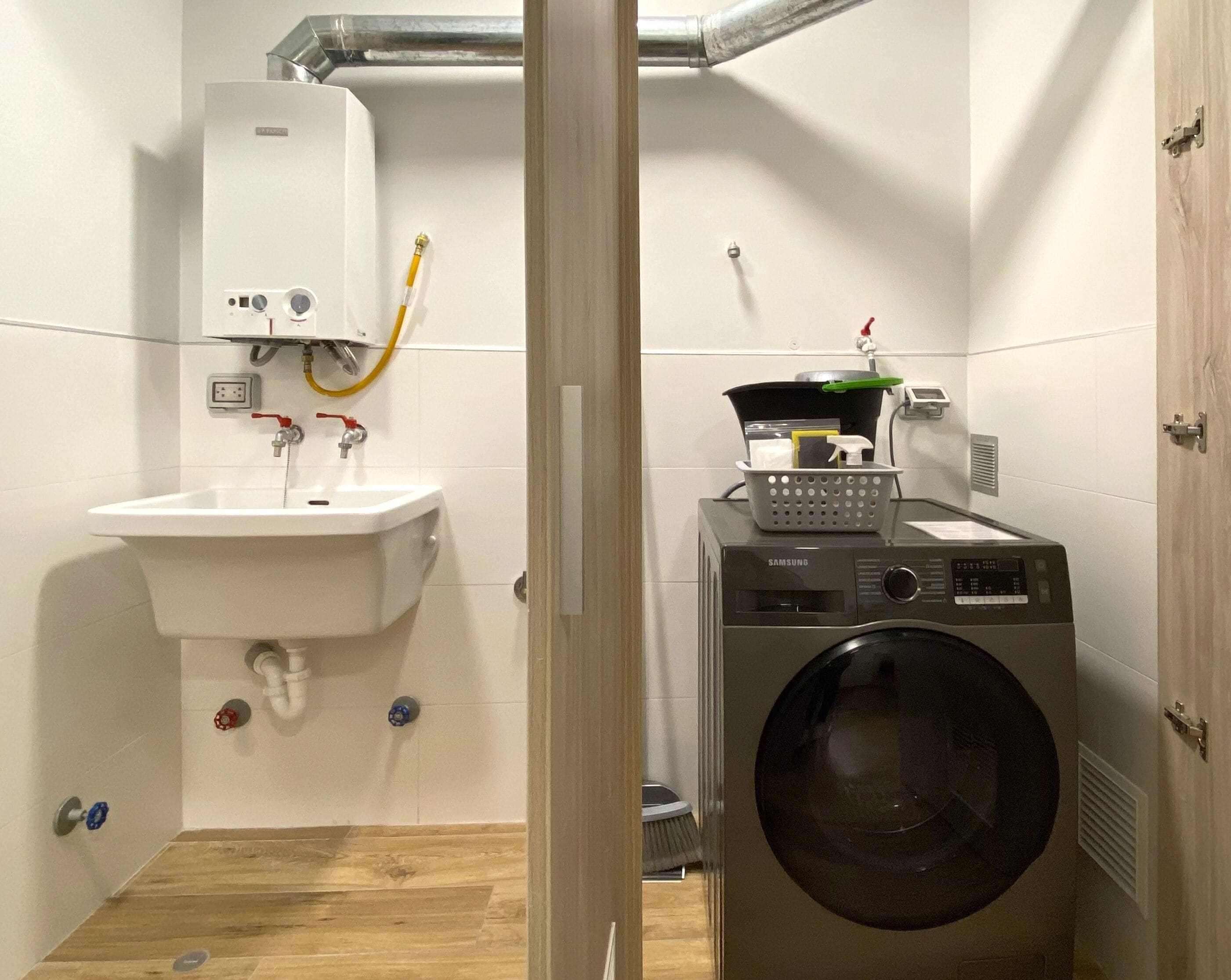Un baño pequeño con lavamanos, lavadora y calefacción.
