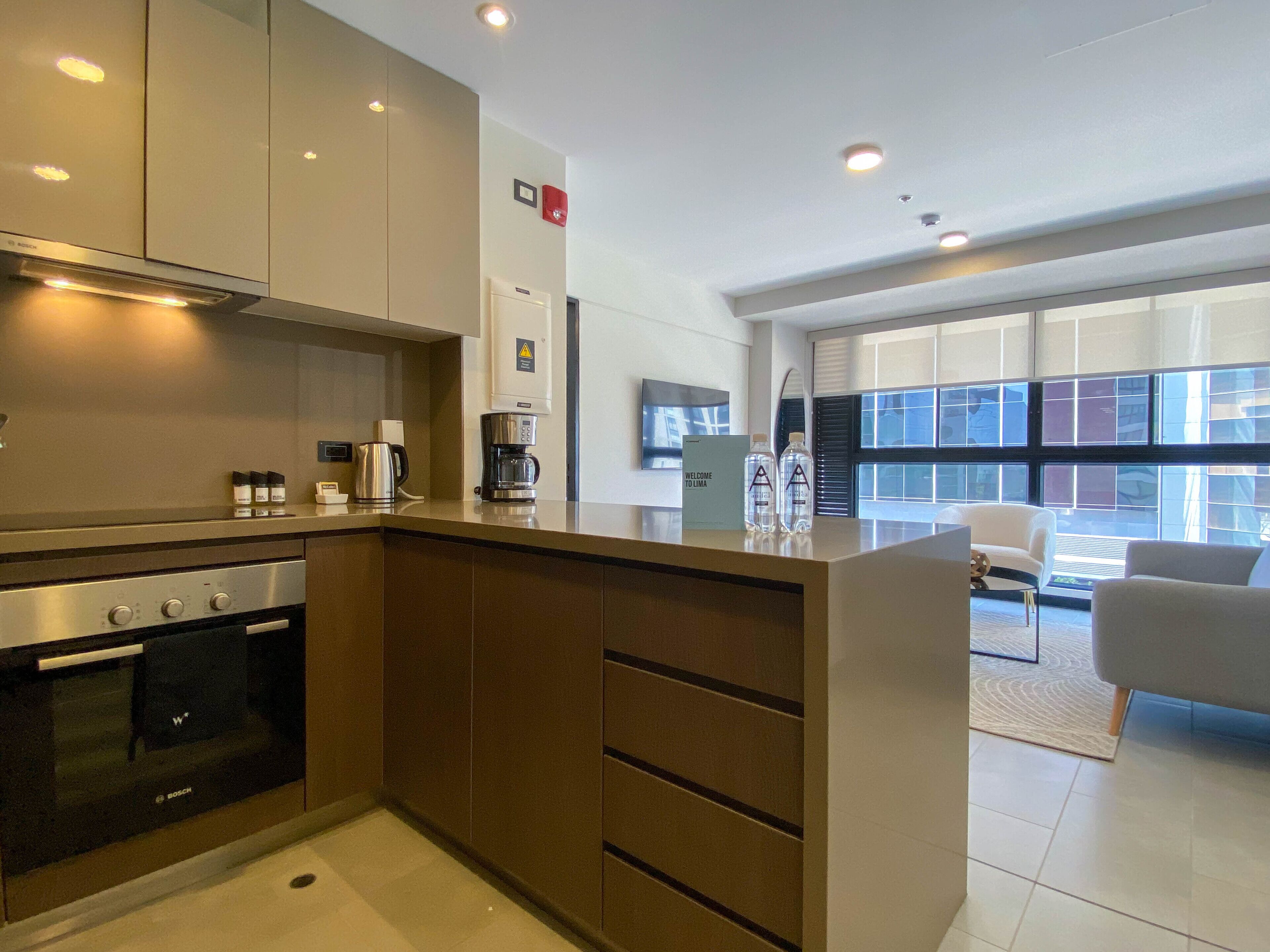 A modern kitchen with a Bosch oven, a coffee maker, and a sign that reads "Welcome to Lima".