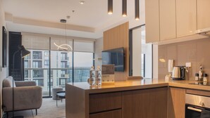 A modern kitchen with a wooden island, a flat-screen TV, and a coffee machine. - Wynwood Rivera Navarrete (Lima)