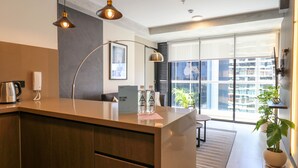 A modern kitchen with a wooden countertop, a kettle, a coffee machine, and a sign welcoming guests. - Wynwood Rivera Navarrete (Lima)