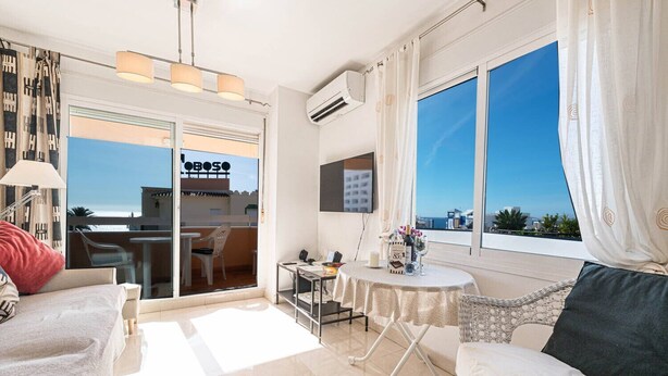 Ein modernes Hotelzimmer mit Balkon, Essbereich und Meerblick.