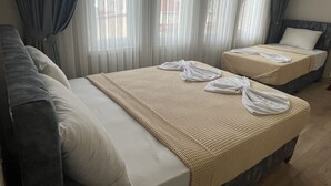 A hotel room with two beds, a sofa, and sheer curtains. - Metropol Hotel 2 (Istanbul)