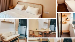 Ett hotellrum med en säng, en soffa, en matplats och ett litet kök.