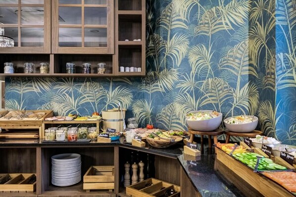 Una mesa de buffet con diversos alimentos y salsas.
