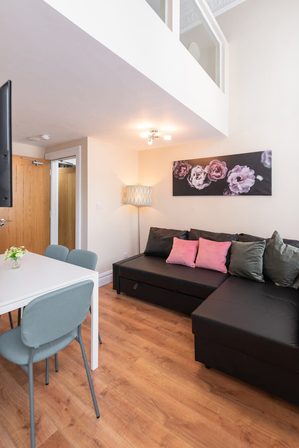 A modern living space with a dining area, a sofa set, and a wall-mounted artwork.