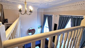 A staircase with white balusters and a chandelier with three lights. - Bright charming - great central location Fast WIFI (Dublin 1)