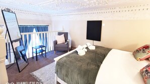 A hotel room with a bed, a chair, a desk, and a large mirror. - Bright charming - great central location Fast WIFI (Dublin 1)