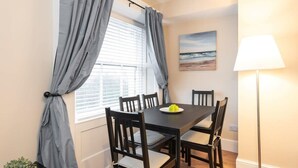 Uma sala de jantar com mesa, cadeiras e abajur.