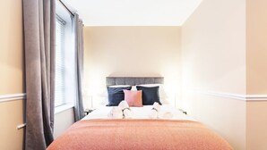 Una camera d'albergo con un letto, tende e una finestra.