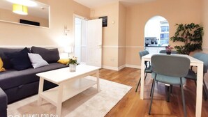 Un salon moderne comprenant un canapé, une table basse et un coin repas avec des chaises et une table.
