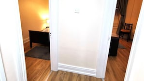 A hallway with a bed, a nightstand, and a lamp. - Central 1bed apartment with reliable fast WIFI (Dublin 1)