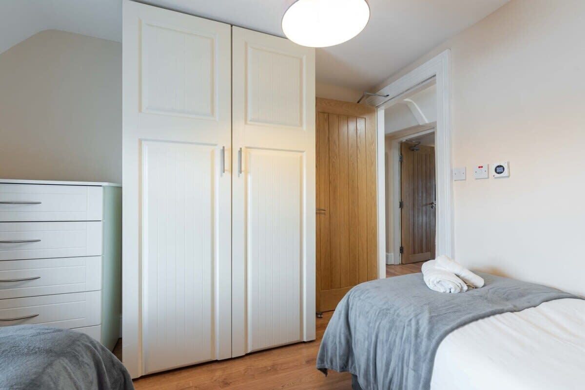 Une chambre à coucher avec un lit, une commode et une armoire.