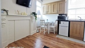 A modern kitchen with wooden cabinets, a microwave, a coffee maker, and a dishwasher. - Cosy studio new renovated - kitchen, TV &Fast WIFI (Dublin)