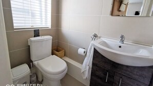 A bathroom with a toilet, sink, and window. - Cosy studio new renovated - kitchen, TV &Fast WIFI (Dublin)