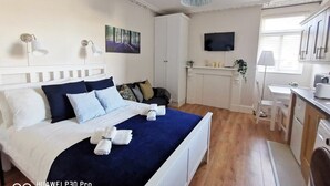 A hotel room with a bed, a desk, a chair, a TV, and a window. - Cosy studio new renovated - kitchen, TV &Fast WIFI (Dublin)