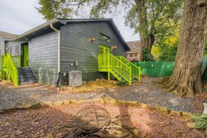 Enter a charming single-story building with a vibrant staircase leading to the entrance, complemented by a cozy fire pit.