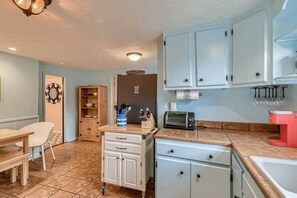 Kitchen area with toaster oven, sink, and dining space.