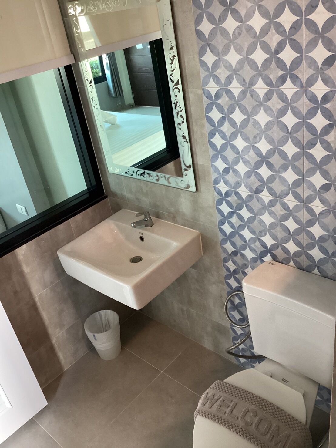 Un baño con lavamanos, inodoro y espejo.