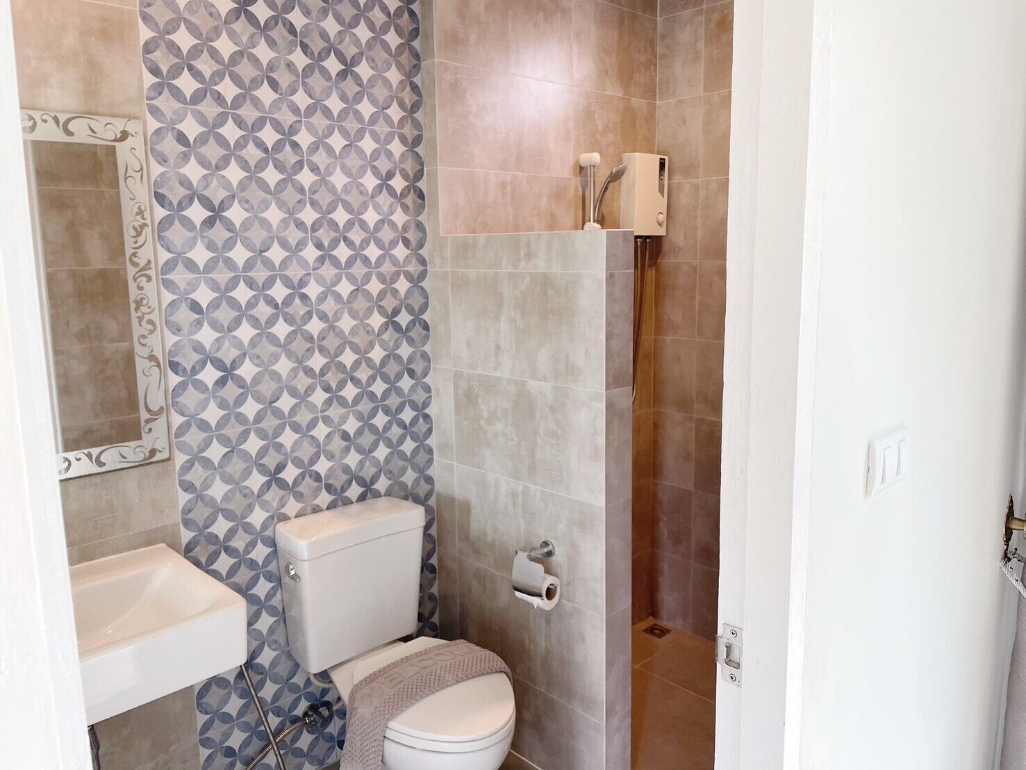 A bathroom with a toilet, sink, and shower.