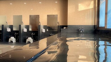 Une salle de bain moderne avec un sol antidérapant, plusieurs lavabos et un grand miroir.
