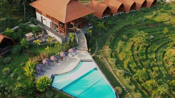 A resort with a swimming pool, a large building with a red roof, and a series of connected huts. - Antagana Retreat (Selemadeg)