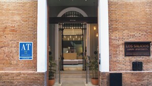 En hotelindgang med et skilt for 'Los Salados Luxury Apartments' og et blåt skilt, der angiver 'Edificio Complejo Ciudad'.