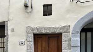 A building facade with a double wooden door, a small window, and a metal utility box. - Uffizi SuiteLarge and elegant renovated apartment in the heart of Florence (Firenze)