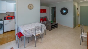 A compact living space with a dining area, kitchenette, and a seating area with a sofa and a coffee table. - Air-conditioned studio, quiet, Menton center, terrace (Menton)