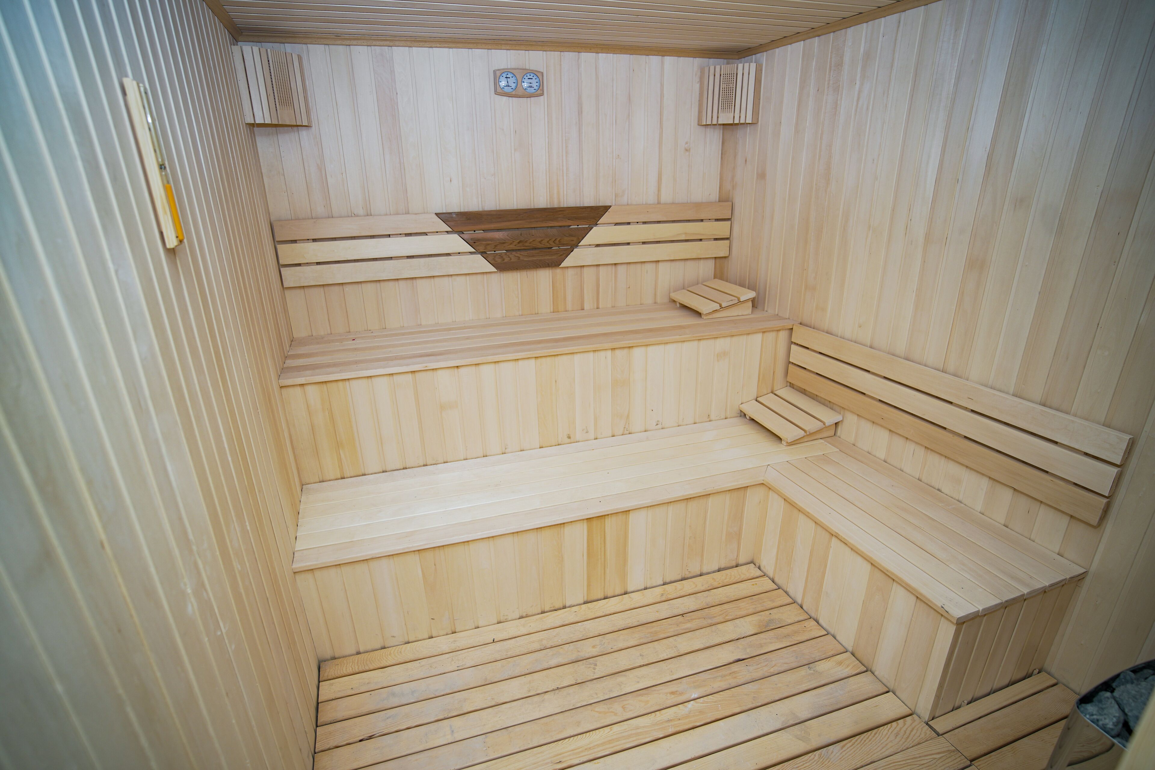 Uma sauna com bancos de madeira e piso inclinado.