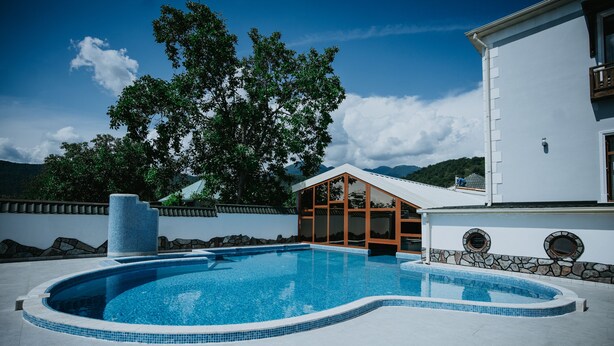 Ein Schwimmbecken mit einer Steinmauer und einer Holzterrasse.