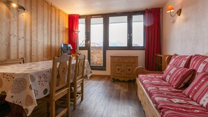 A cozy room with a wooden interior, a dining table with chairs, a sofa, and a window with a view. - Central apartment for 6 pers, TV, WiFi, ski locker (Avoriaz)